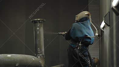 Worker Sandblasting Gas Pipe