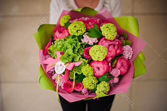 Girl holding bouquet of pink and green flowers