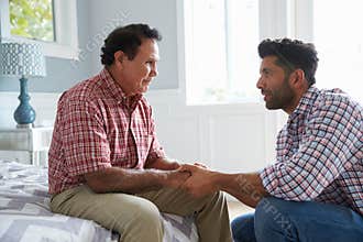 Adult Son Comforting Father Suffering With Dementia