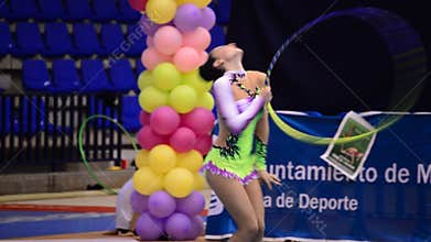 Young gymnast with ring on a rhythmic gymnastics tournament
