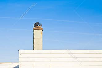 Old metal chimney on the roof of a wooden house - image with cop