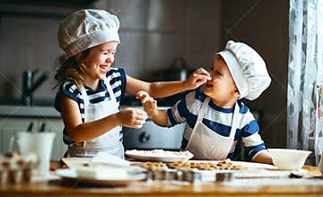 Happy family funny kids bake cookies in kitchen