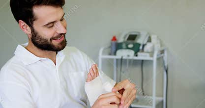 Physiotherapist putting bandage on injured feet of patient