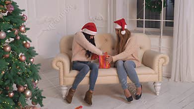 Female tearing wrapping paper on present.