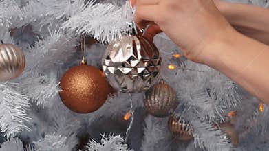 Young woman decorating Christmas tree with baubles.New year preparation,close up