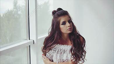 Attractive young woman brunette posing sitting near the window