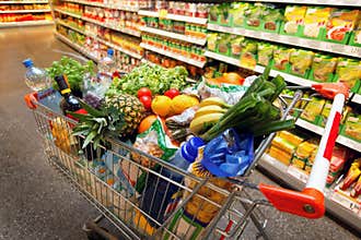 Shopping cart with fruit in supermarket