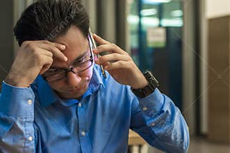 Close up of depressed and frustrated businessman on the phone. Bad news. Worried young businessman