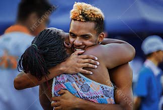 Two athletes embrace to celebrate victory at World Roller Skating