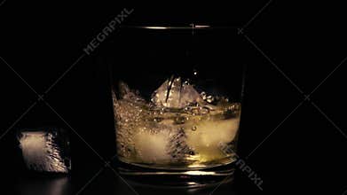 Slow mo whiskey in glass with ice
