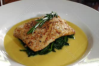 Baked tilapia over steamed spinach