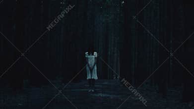 Female ghost in white dress in the dark forest