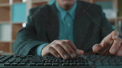 Office worker in plaid jacket blue shirt fast typing on computer keyboard