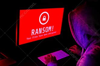 Computer screen with ransomware attack alerts in red and a hacker man keying on keyboard in a dark room, ideal for online