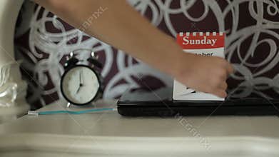 Morning of a business woman. Morning student. Female hand flips the calendar sheet.