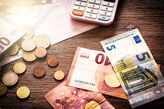 Euro banknotes and coins with bills to pay