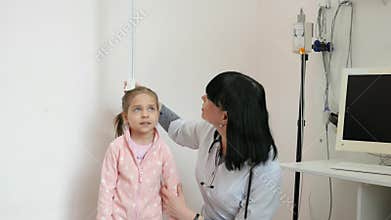 Doctor measures growth of patient, child at doctor`s appointment, nurse works in hospital, sick child in children`s