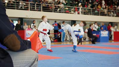 Referee of martial arts - children karate holds red and blue flags