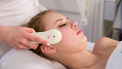 High frequency skin treatment of female face in spa