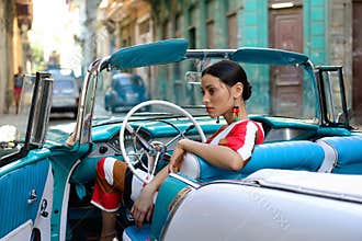 Beautiful Cuban woman in the classical American car
