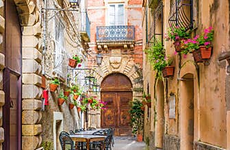 Cafe tables and chairs outside in old cozy street in the Positano town, Italy