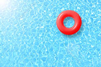Red swimming pool ring float in blue water and sun bright.