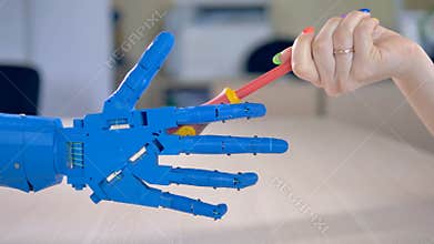 A bionic hand takes a screwdriver.