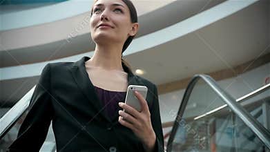Happy young woman using smart phone in shopping mall. Businesswoman freelancer with smartphone in airport terminal