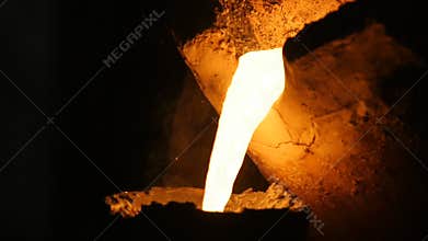 Wonderful view red hot liquid metal flows in darkness