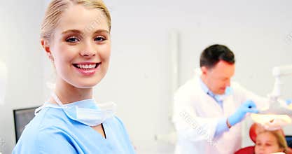 Smiling dental assistant standing in dental clinic