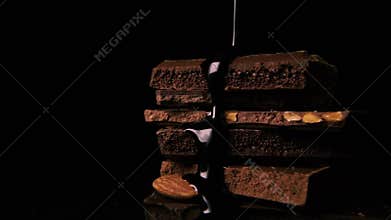 Dark hot chocolate pours down on chocolate. Slow motion