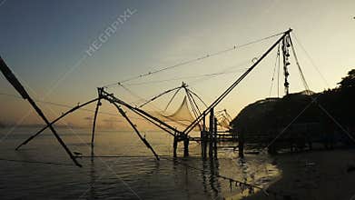 Sunrise over chinese fishing nets and boat in Cochin, India