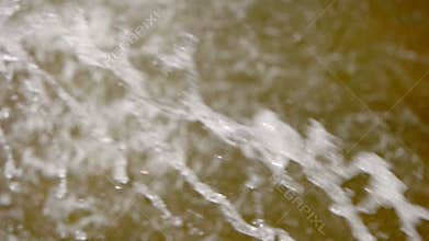 Blur Slow-motion water drops and splashes fly in an air. City park fountain working.