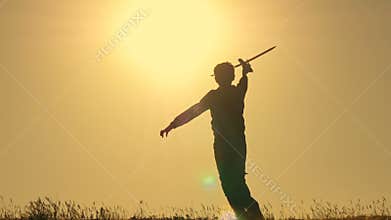 Boy playing with airplane model against orange sunset background