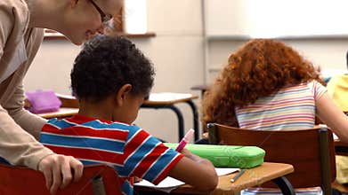 Teacher helping a little boy during class