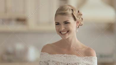 Young bride in a lace wedding dress laughing at