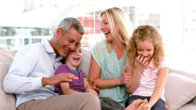 In slow motion happy family sitting on sofa