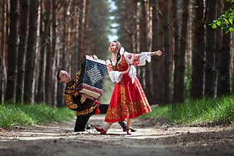 Couple dancing in russian traditional dress on nature