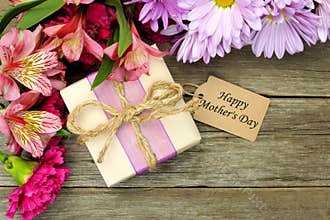 Mother's Day gift box and flowers on wood