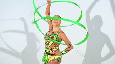 Beautiful acrobat dancing with a sash in slow motion