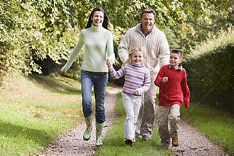 Family running along woodland track