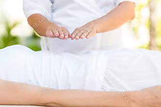 Calm woman receiving reiki treatment