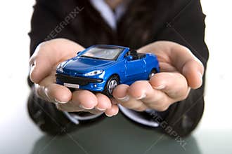 Businesswoman holding car in the hands