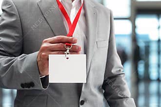 Businessman holding blank ID badge