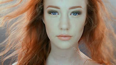 Beautiful teenage girl with red blowing hair and