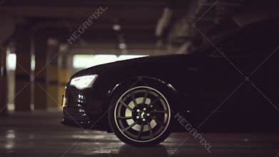 Black Audi leaves the parking lot with its lights