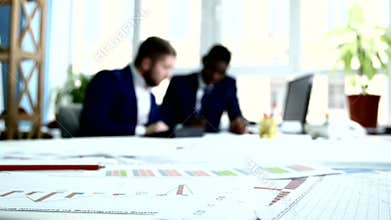 Two businessmen in blue suits are estimates. Focus