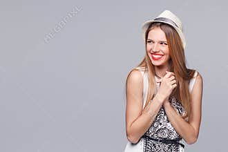 Surprised happy young woman looking sideways in excitement. Isolated over gray