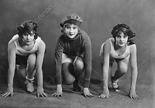 Portrait of three female runners in starting position