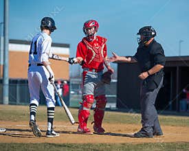 High School Baseball batter hands ball to catcher
